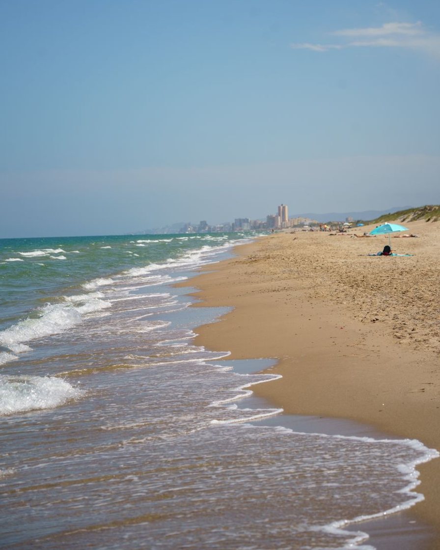 Vista aérea del frente marítimo con dársena, playa recta y manzanas bajas detrás